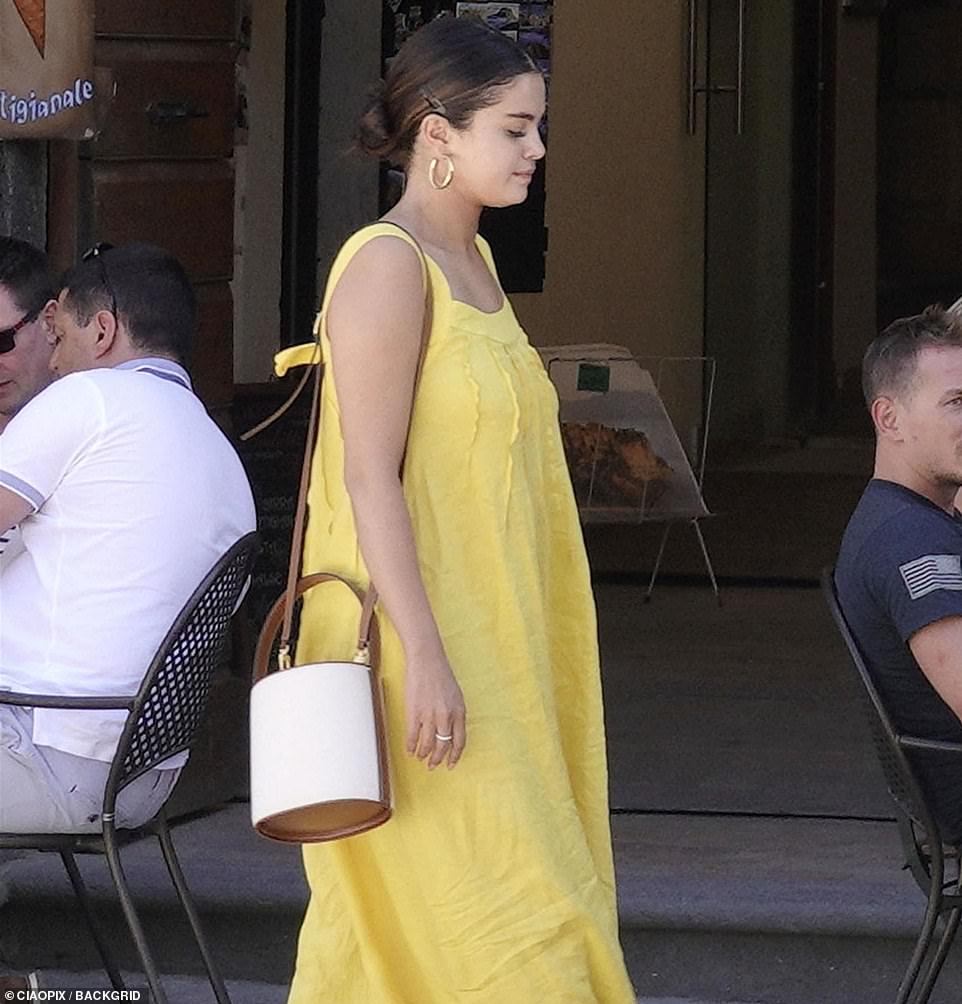 Keeping her belongings close by: Selena accessorised her vacation look with a white bucket bag