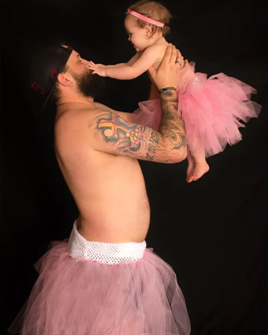 Dad and little daughter together wearing princess dresses for a photo