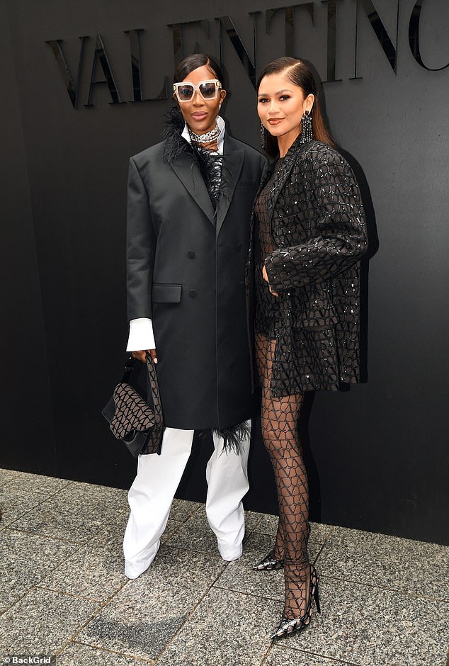 Making friends: She soon joined catwalk veteran Naomi Campbell (left), who looked the epitome of chic in a black feather coat which she wore over a white shirt and trousers